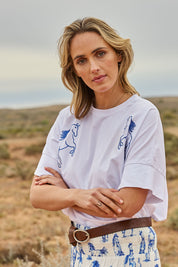 Model Tegan wearing size 10 of the Loving Life Embroidered Tee in colour Horses (White), from the front, showing the whole outfit