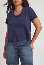 Model Terri-Leigh wearing size 14 of the Saturday Night Low Back Tee in colour Marledenim (Blue), from the front, cropped image