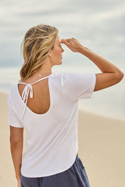 Model Tegan wearing size 10 of the Saturday Night Low Back Tee in colour White (White), from the back