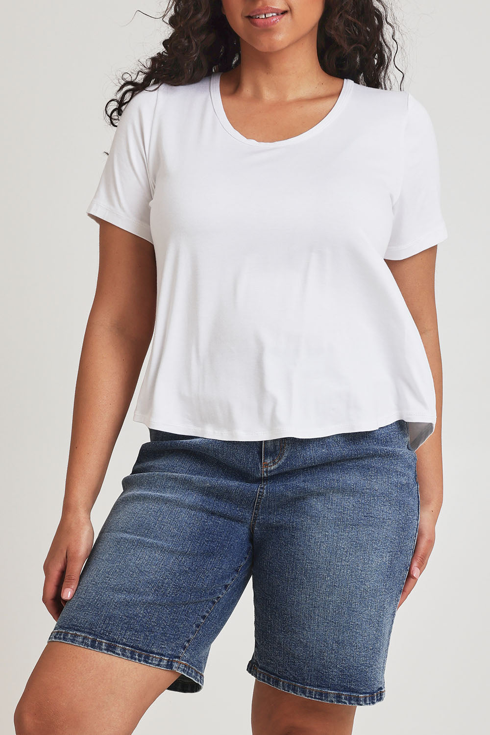 Model Terri-Leigh wearing size 14 of the Saturday Night Low Back Tee in colour White (White), from the front, cropped image
