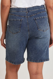 Model Terri-Leigh wearing size 14 of the Daily Dose Longline Denim Shorts in colour Denim (Blue), from the back
