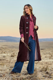 Model Tegan wearing size 10 of the Winter Walk Longline Cord Duffle Coat in colour Aubergine (Purple), from the front, showing the whole outfit