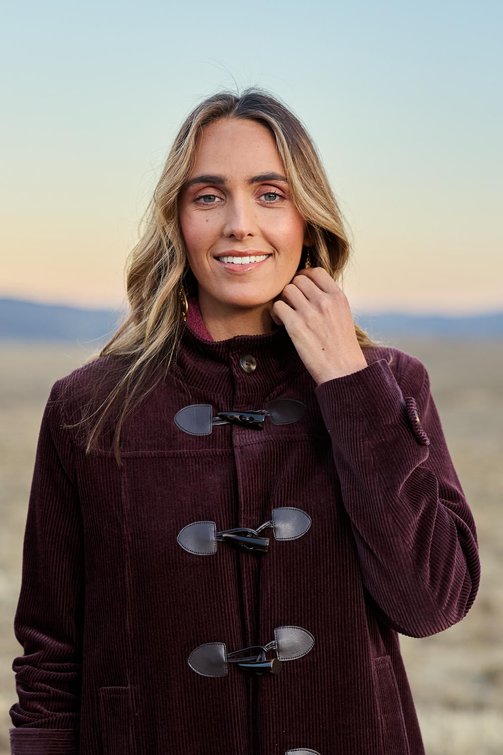 Model Tegan wearing size 10 of the Winter Walk Longline Cord Duffle Coat in colour Aubergine (Purple), from the front, showing the whole outfit