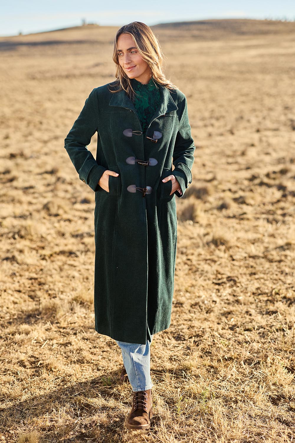 Model Tegan wearing size 10 of the Winter Walk Longline Cord Duffle Coat in colour Jade (Green), from the front, showing the whole outfit