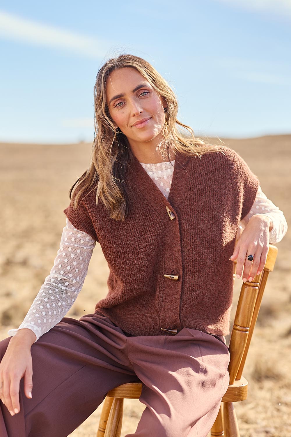 Model Tegan wearing size S of the Found My Friend Recycled Knit Sleeveless Cardi in colour Copper, from the front, showing the whole outfit