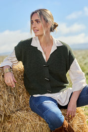 Model Tegan wearing size S of the Found My Friend Recycled Knit Sleeveless Cardi in colour Pine (Green), from the front, showing the whole outfit