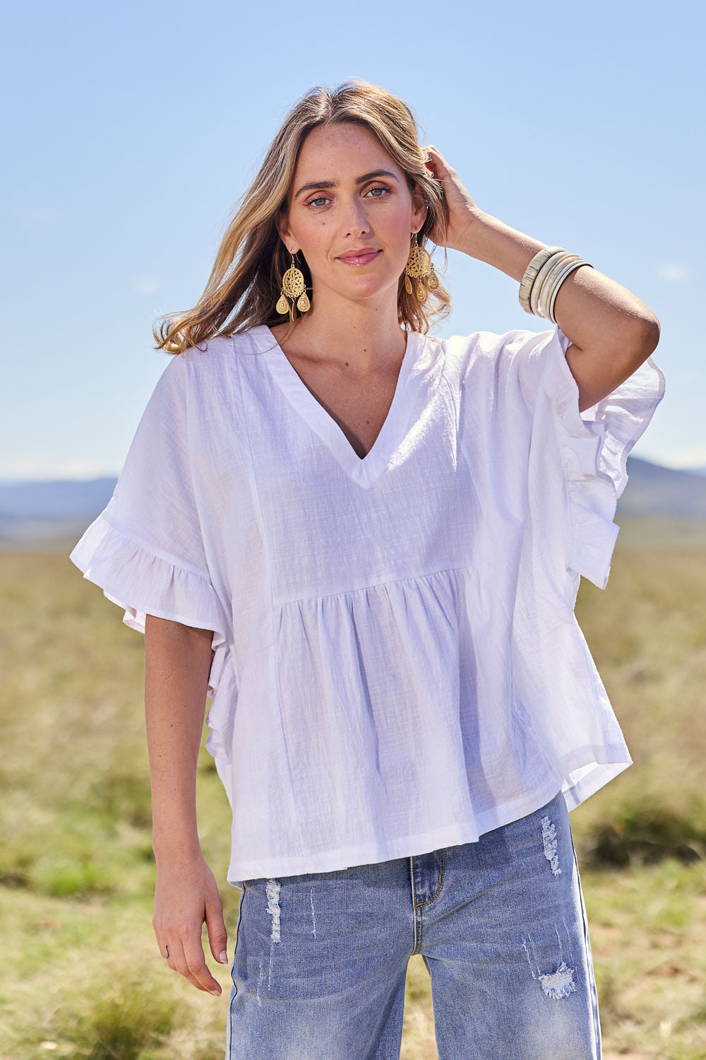 Model Tegan wearing size 10 of the Fun Times Cotton Flounce Top in colour White (White), from the front, showing the whole outfit