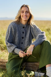 Model Tegan wearing size S of the Level Up Cropped Cable Cardi in colour Smoke (Grey), from the front, showing the whole outfit
