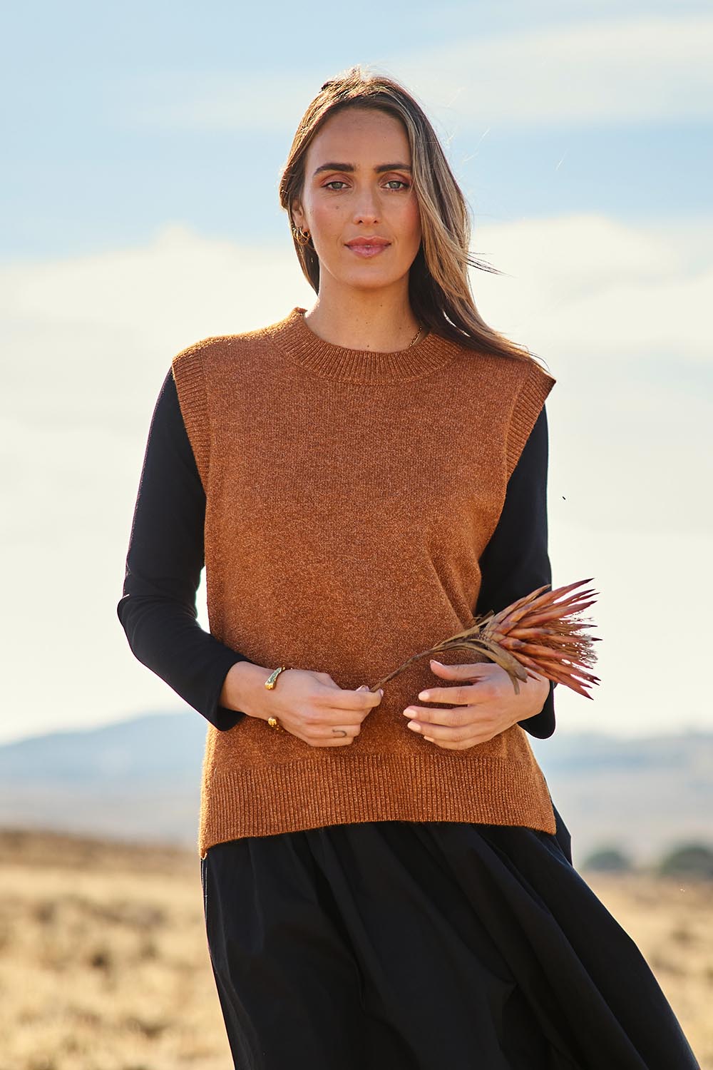 Model Tegan wearing size S of the Found My Friend Recycled Knit Vest in colour Ochre, from the front, showing the whole outfit