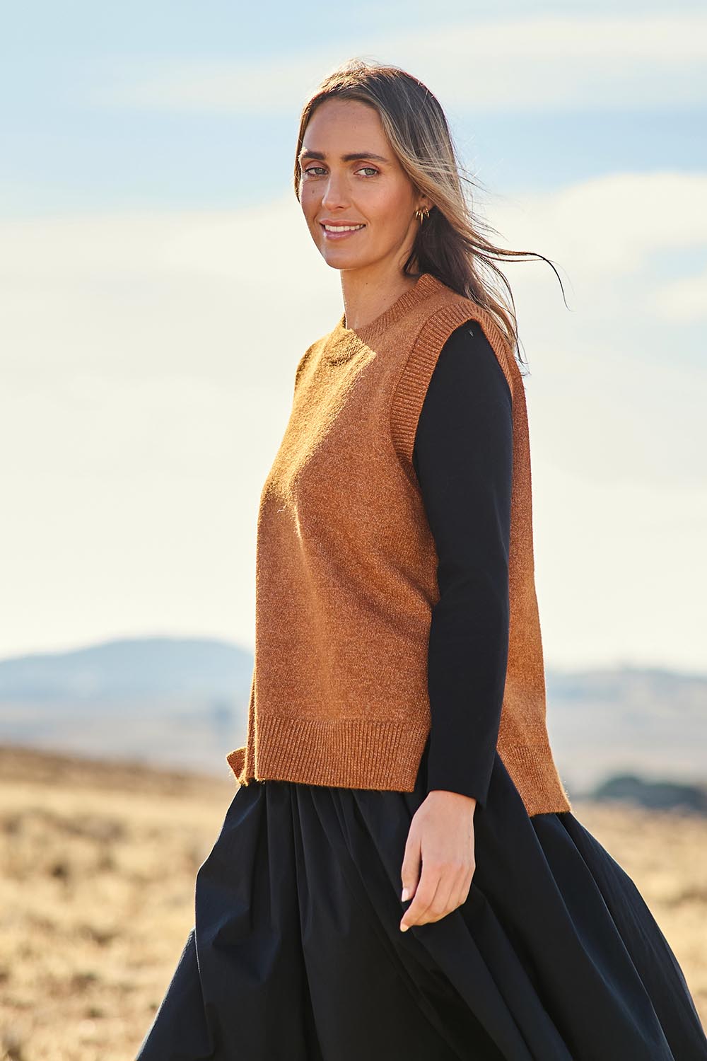 Model Tegan wearing size S of the Found My Friend Recycled Knit Vest in colour Ochre, from the front, showing the whole outfit