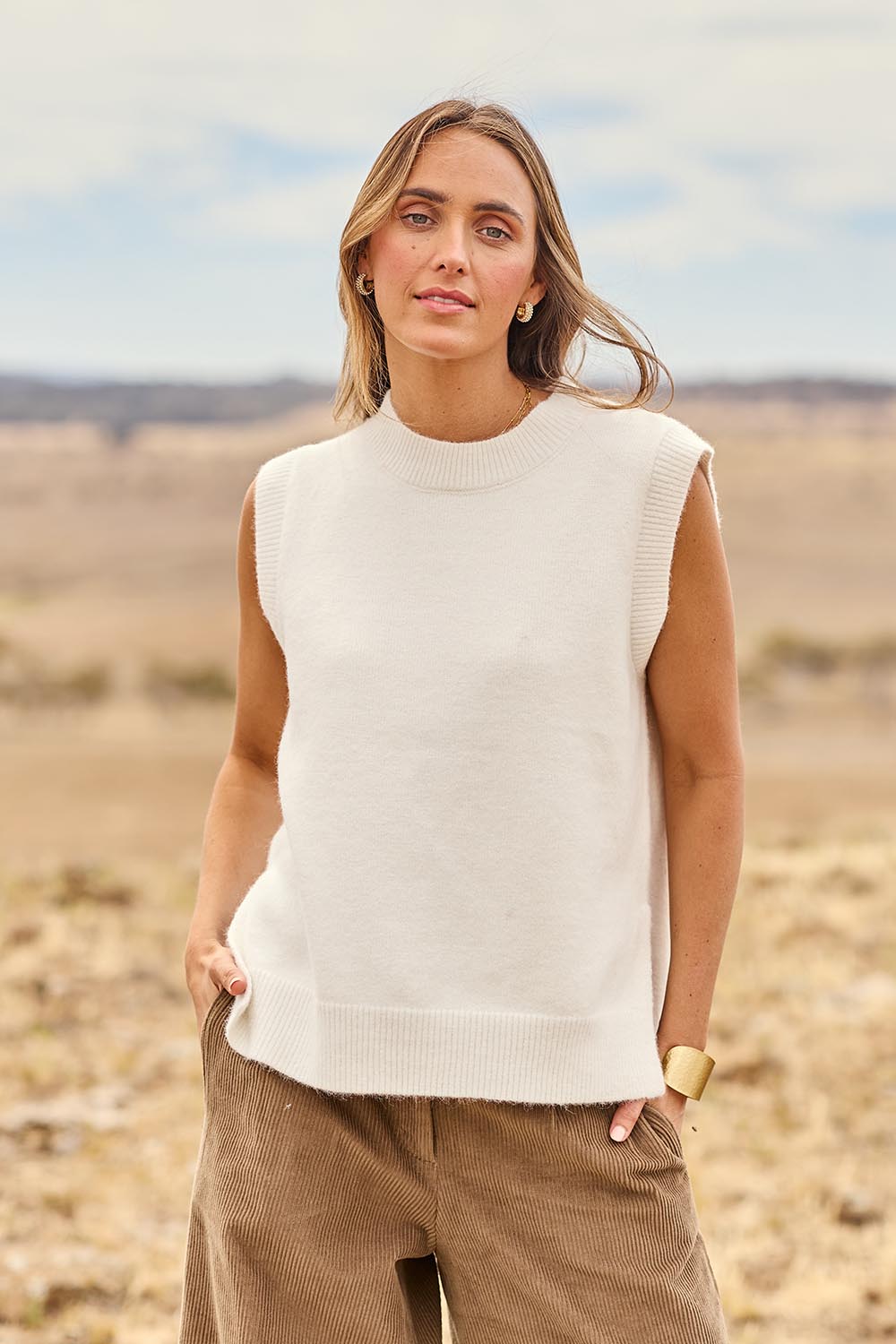 Model Tegan wearing size S of the Found My Friend Recycled Knit Vest in colour Snow (White), from the front, showing the whole outfit