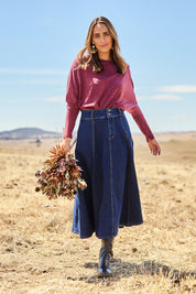 Model Tegan wearing size 10 of the Sparking Joy Denim Panelled Skirt in colour Denim (Blue), from the front, showing the whole outfit