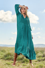 Model Tegan wearing size 10 of the Meadow Meander Smocked Dress in colour Jade (Green), from the front, showing the whole outfit