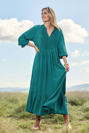 Model Tegan wearing size 10 of the Meadow Meander Smocked Dress in colour Jade (Green), from the front, showing the whole outfit