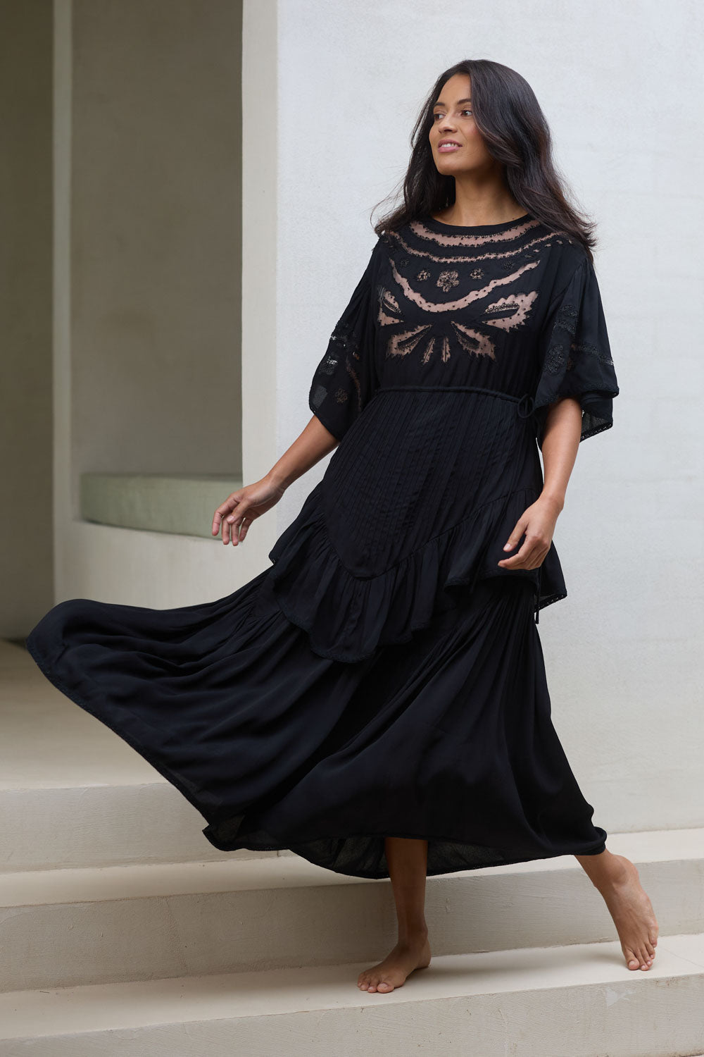 Model Tahnee wearing size 10 of the Eternal Grace Layered Dress in colour Black (Black), from the front, showing the whole outfit