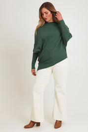 Model Chanel wearing size XL of the Snuggle Up True Knit Jumper in colour Pine (Green), from the front, showing the whole outfit