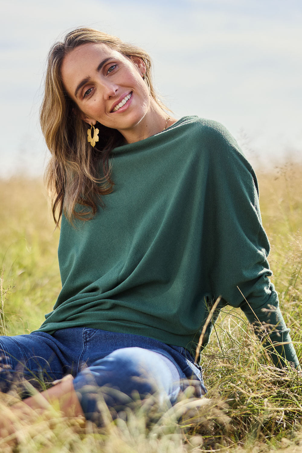 Model Tegan wearing size S of the Snuggle Up True Knit Jumper in colour Pine (Green), from the front, showing the whole outfit