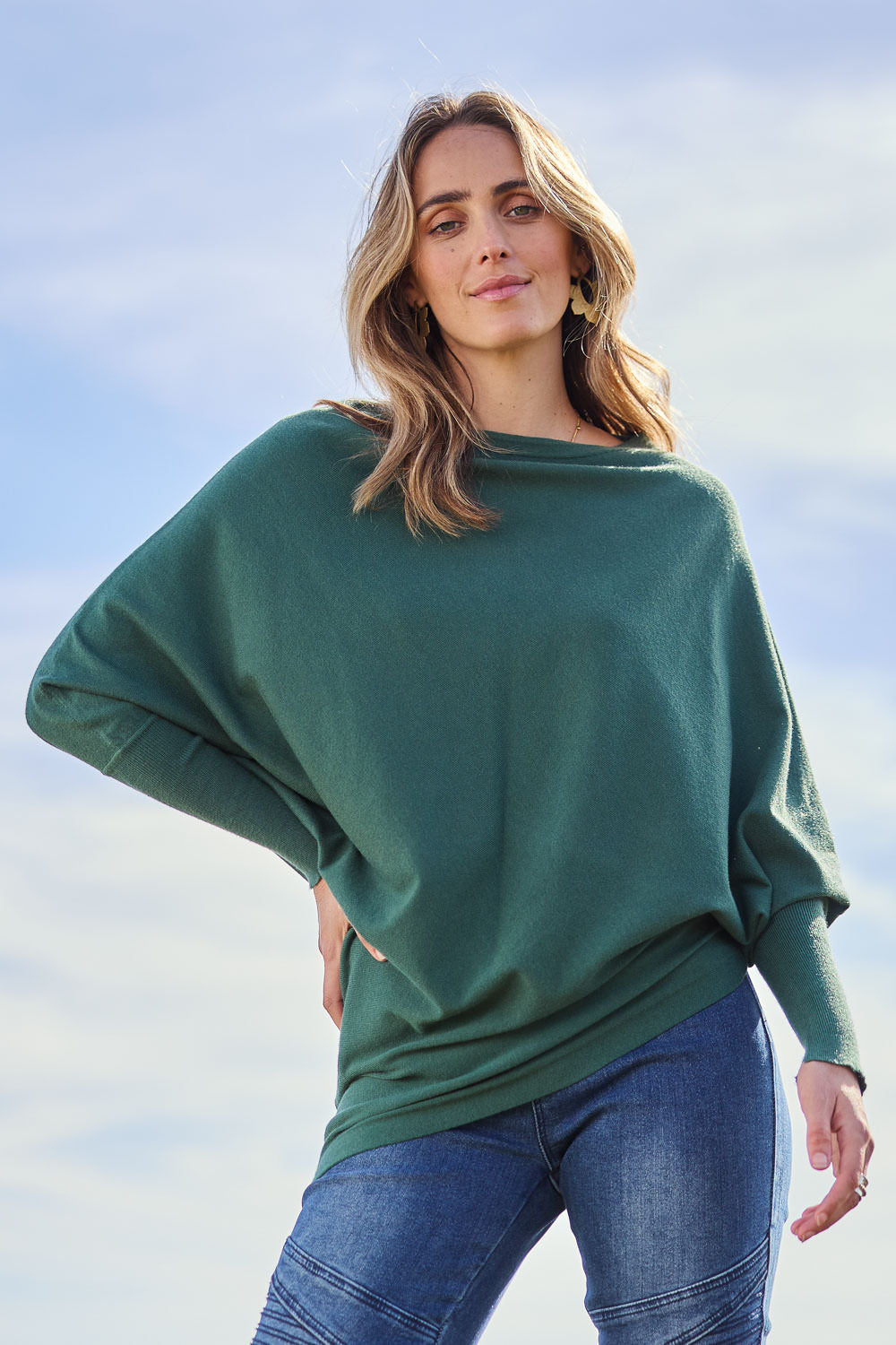 Model Tegan wearing size S of the Snuggle Up True Knit Jumper in colour Pine (Green), from the front, showing the whole outfit