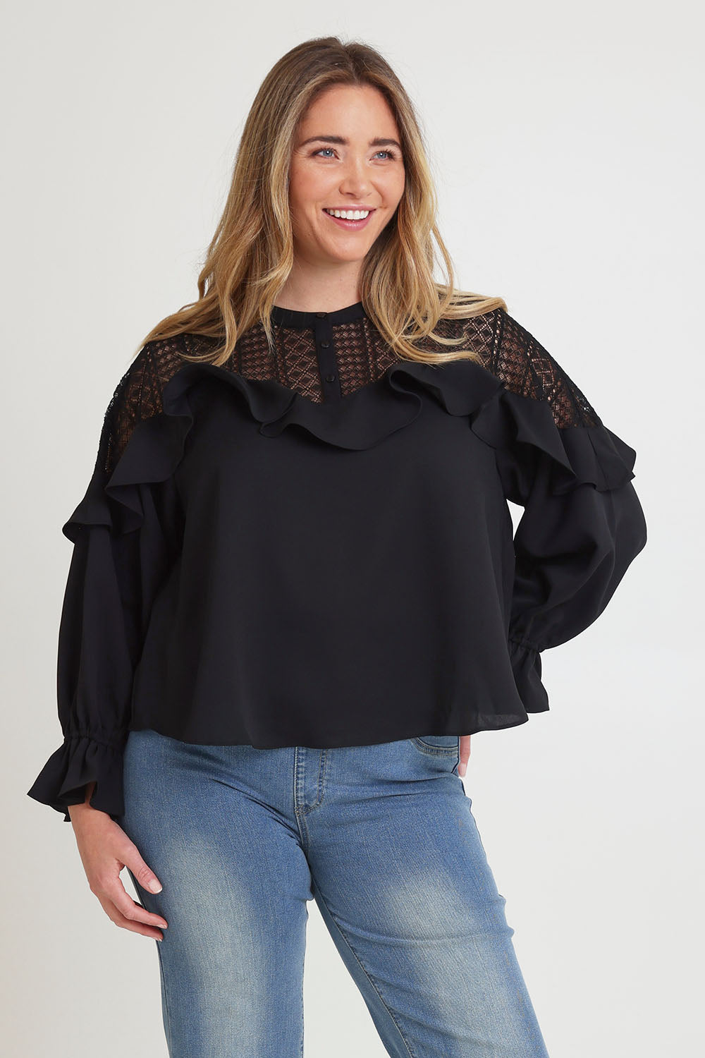 Model Chanel wearing size 16 of the Good Feels Lace Detail Blouse in colour Black (Black), from the front, cropped image