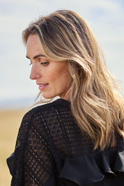 Model Tegan wearing size 10 of the Good Feels Lace Detail Blouse in colour Black (Black), from the back