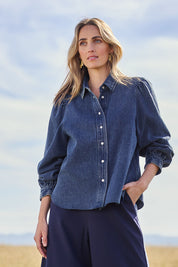 Model Tegan wearing size 10 of the Denim Daze Billow Sleeve Shirt in colour Denim (Blue), from the front, showing the whole outfit