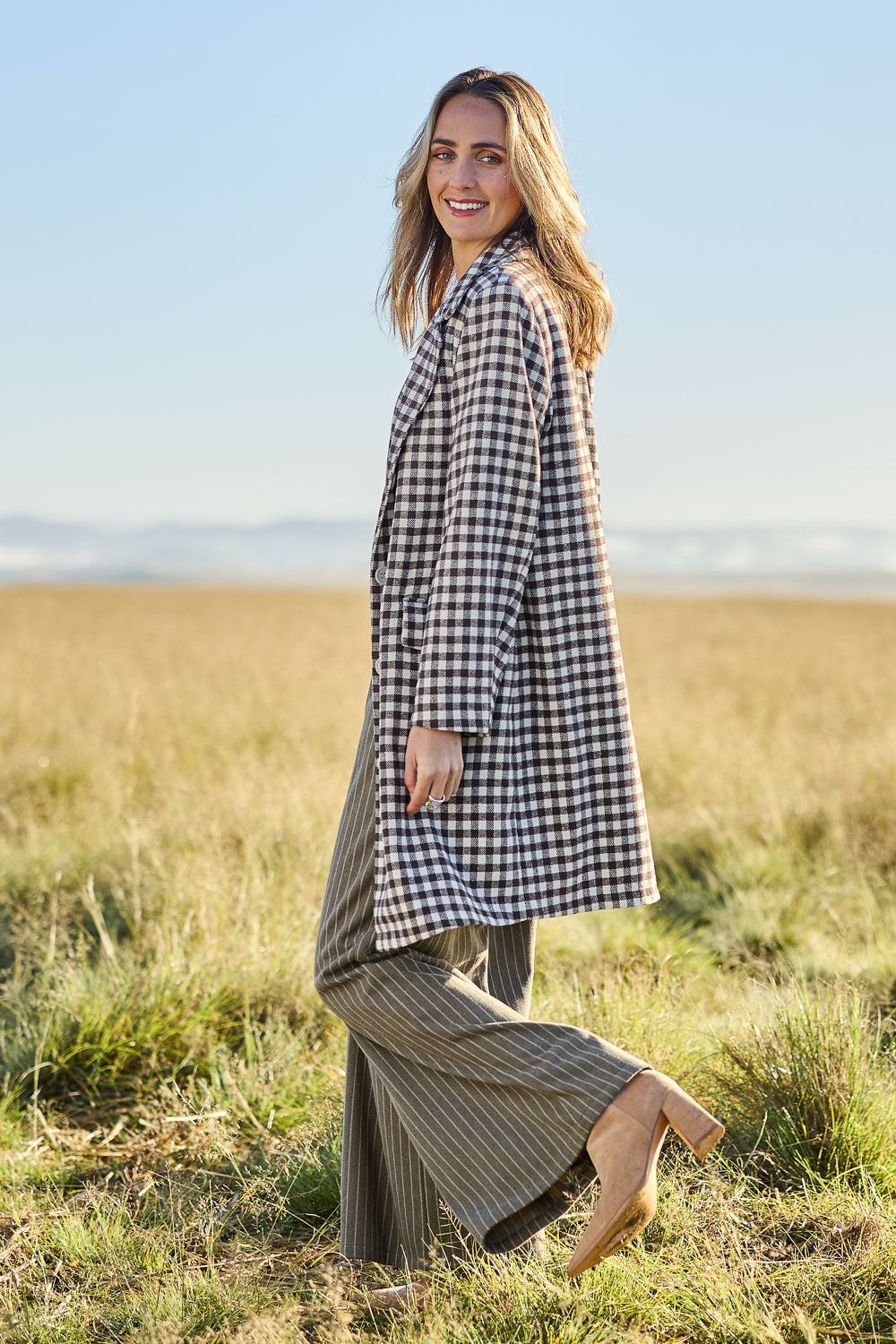Model Tegan wearing size 10 of the Checked In Overcoat in colour Chocheck, from the front, showing the whole outfit