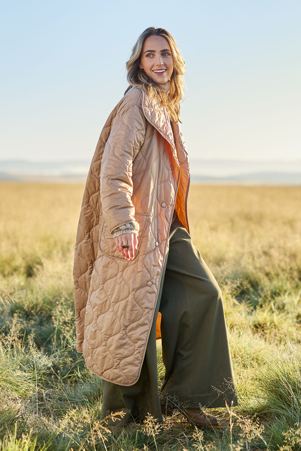 Model Tegan wearing size 10 of the Heart Warming Oversized Quilted Jacket in colour Earth, from the front, showing the whole outfit