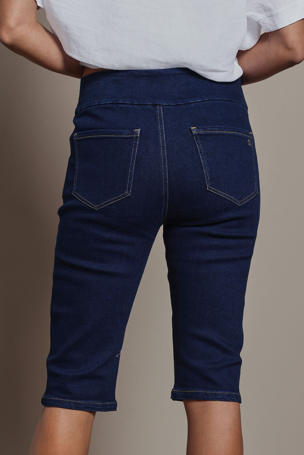 Model Amanda wearing size 10 of the Easy As Pull On Long Shorts in colour Denim (Blue), from the back