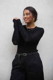 Model Tahnee wearing size S of the Love Layer Long Sleeve Knit Top in colour Black (Black), from the front, showing the whole outfit