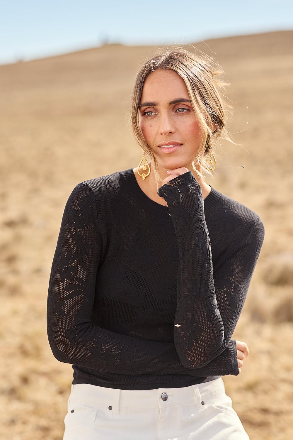 Model Tegan wearing size S of the Love Layer Long Sleeve Knit Top in colour Black (Black), from the front, showing the whole outfit