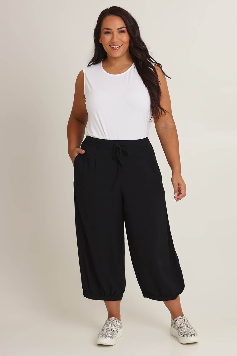 Model Ashleigh wearing size 16 of the Summer Daze Linen Blend Pull On 3/4 Pant in colour Black (Black), from the front, showing the whole outfit