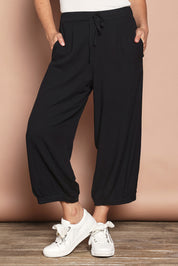 Model Katie wearing size 10 of the Summer Daze Linen Blend Pull On 3/4 Pant in colour Black (Black), from the front, cropped image