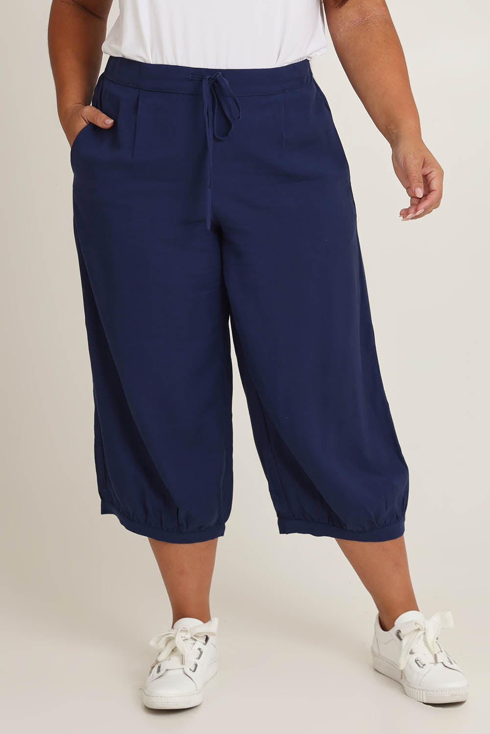 Model Ashleigh wearing size 16 of the Summer Daze Linen Blend Pull On 3/4 Pant in colour Navy (Blue), from the front, cropped image