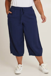 Model Ashleigh wearing size 16 of the Summer Daze Linen Blend Pull On 3/4 Pant in colour Navy (Blue), from the front, cropped image