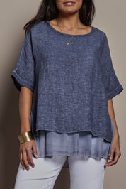Model Tahnee wearing size 10 of the Layers Of Love Linen Overlay Top in colour Denim (Blue), from the front, cropped image