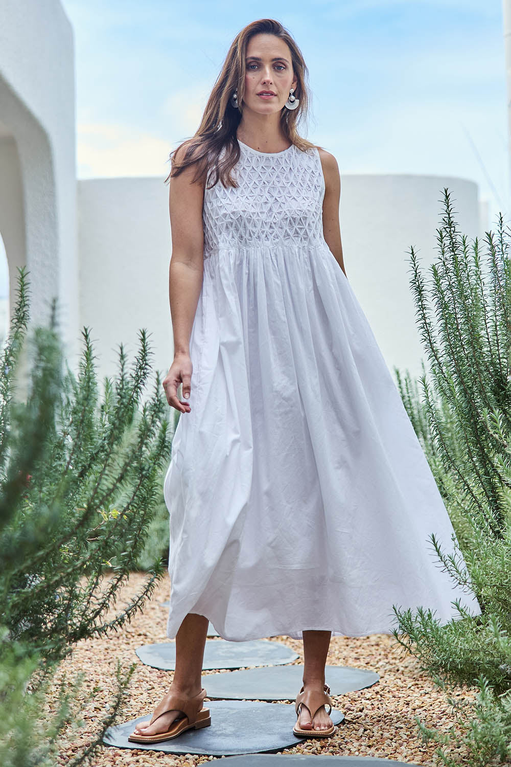 Model Tegand wearing size 10 of the Summer Breeze Smocked Cotton Dress – White in colour White, from the front