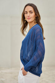 Model Tegand wearing size 10 of the Summer Haze Cardigan – Denim in colour Denim, from an angle