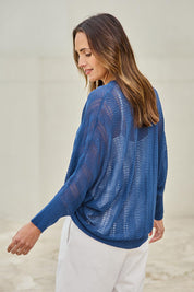 Model Tegand wearing size 10 of the Summer Haze Cardigan – Denim in colour Denim, from an angle