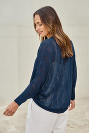 Model Tegand wearing size 10 of the Summer Haze Cardigan – Denim in colour Denim, from an angle