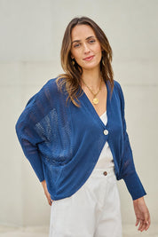 Model Tegand wearing size 10 of the Summer Haze Cardigan – Denim in colour Denim, in a cropped view
