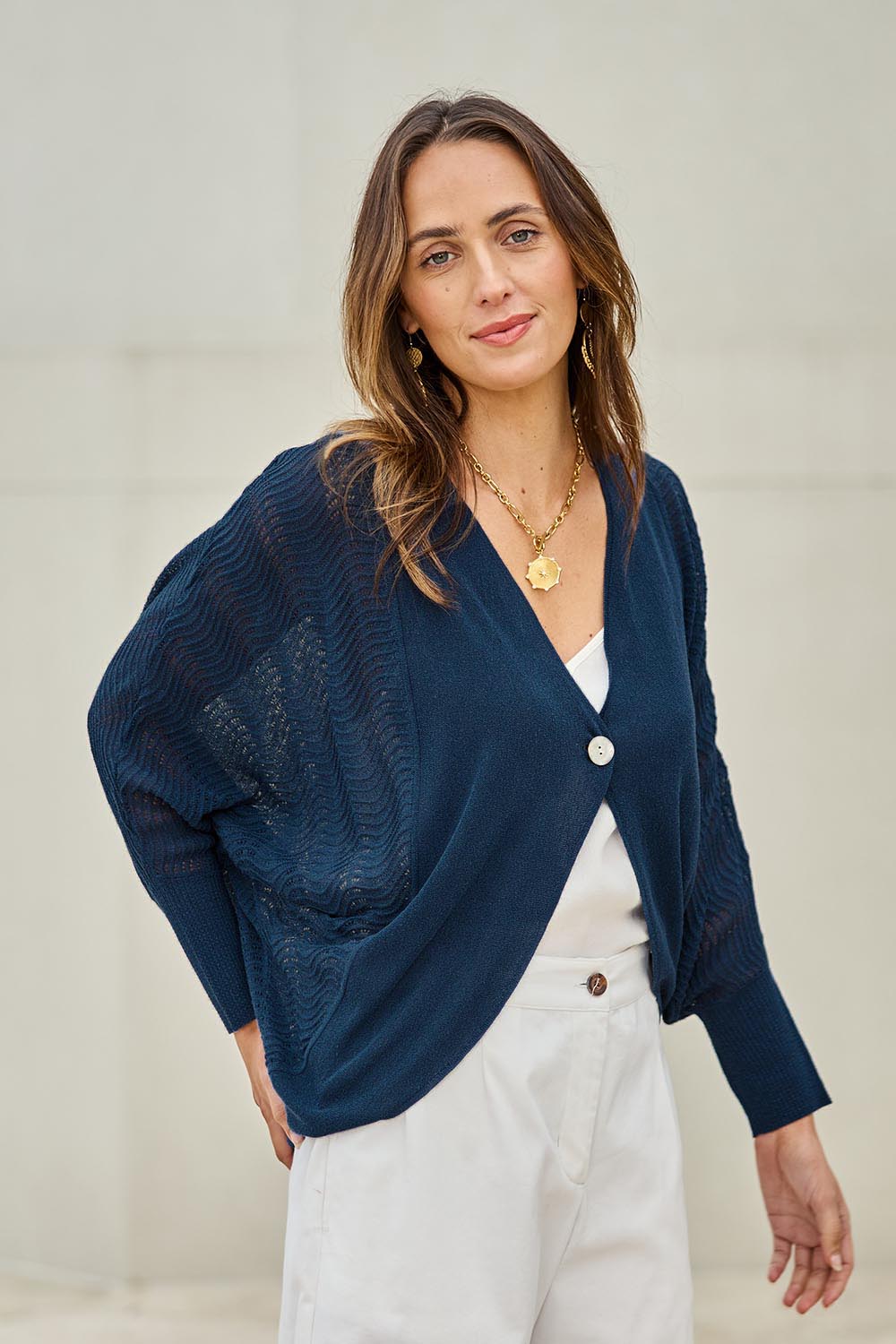 Model Tegand wearing size 10 of the Summer Haze Cardigan – Denim in colour Denim, in a cropped view