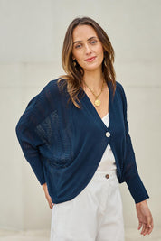 Model Tegand wearing size 10 of the Summer Haze Cardigan – Denim in colour Denim, in a cropped view