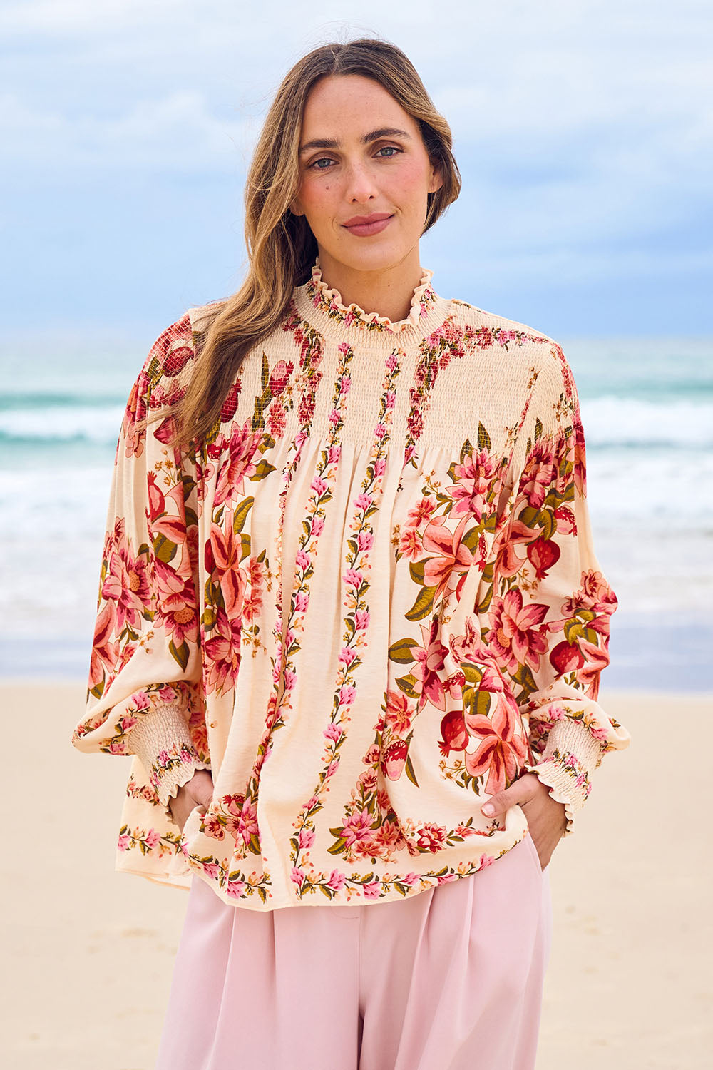 Model Tegan wearing size 10 of the Floral Affair Blouse in colour Creamfleur (Pink), from the front, showing the whole outfit