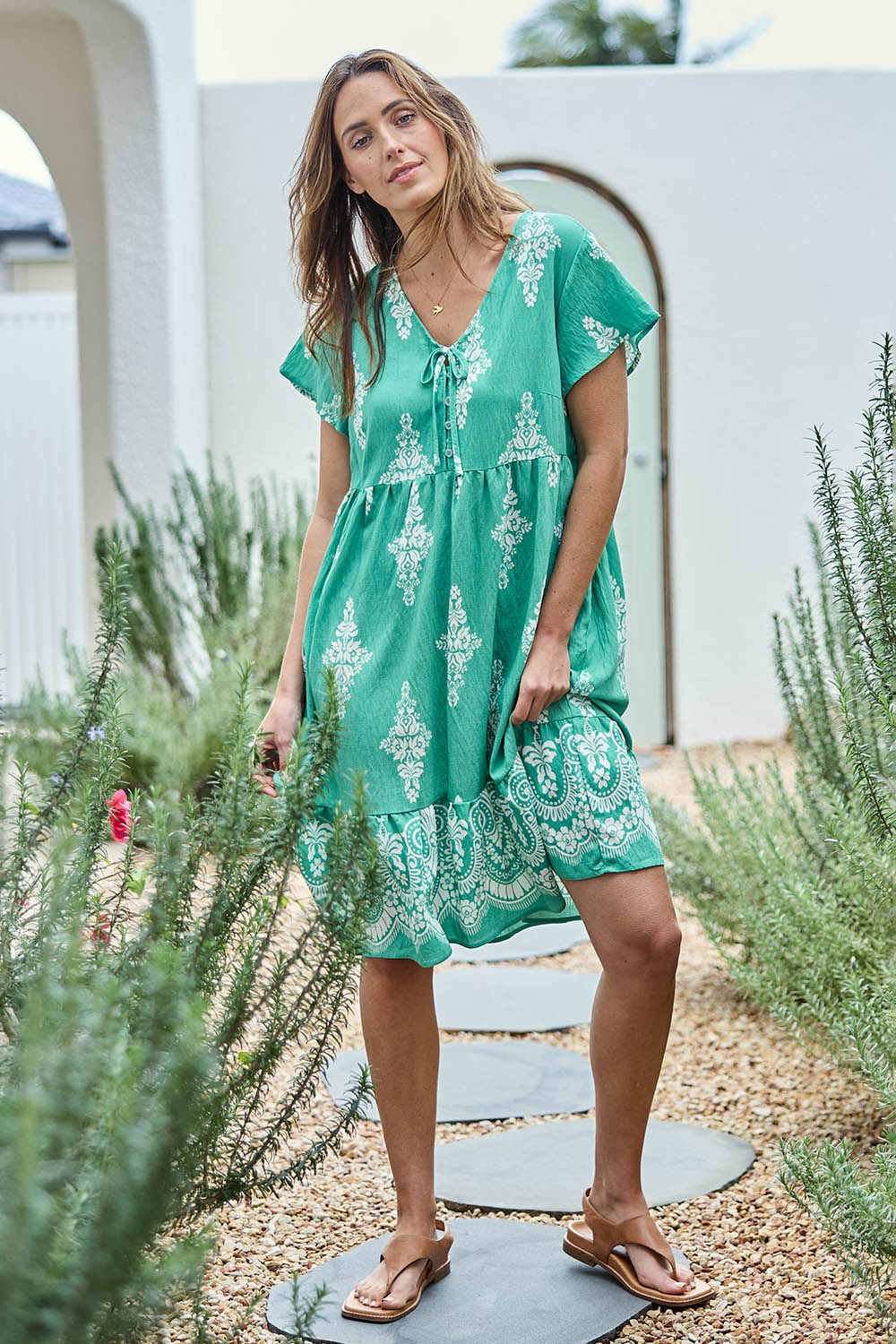 Model Tegand wearing size 10 of the Sunset Happy Hour Dress – Leaf in colour Leaf, from the front
