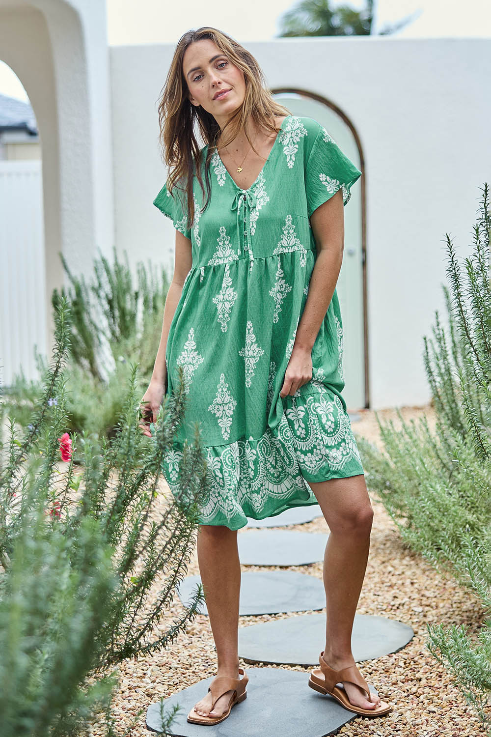 Model Tegand wearing size 10 of the Sunset Happy Hour Dress – Leaf in colour Leaf, from the front