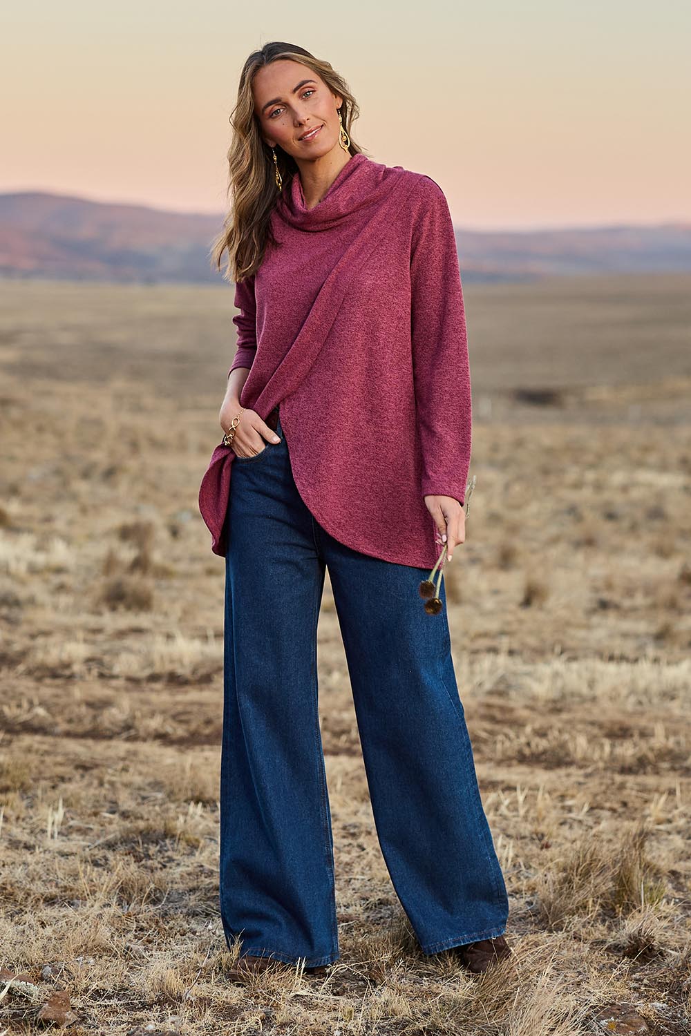 Model Tegan wearing size 10 of the Crossing The Plains Snuggle Jumper in colour Grape (Purple), from the front, showing the whole outfit