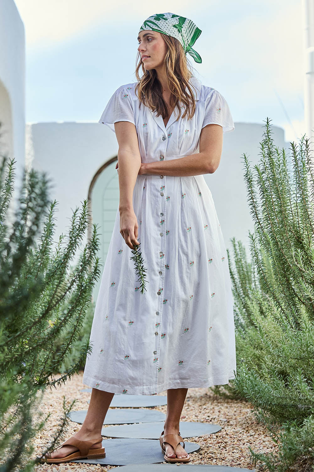 Model Tegand wearing size 10 of the Flower Field Cotton Embroidered Dress – White in colour White, from the front