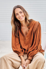 Model Tegand wearing size 10 of the Out And About Cotton Blouse – Rust in colour Rust, in a cropped view