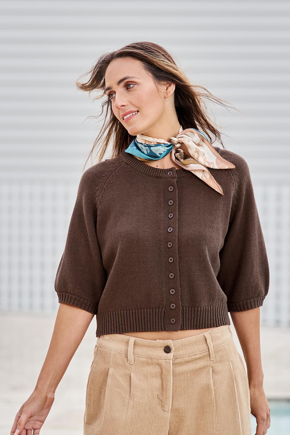 Model Tegand wearing size 10 of the Clear Skies Balloon Sleeve Cotton Blend Cardi – Chocolate in colour Chocolate, from an angle