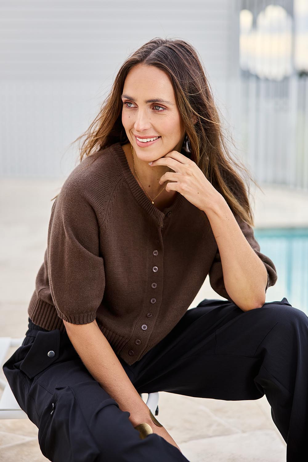 Model Tegand wearing size 10 of the Clear Skies Balloon Sleeve Cotton Blend Cardi – Chocolate in colour Chocolate, from an angle